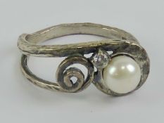 An Arts and Crafts style hand planished silver ring set with pearl and white stone, size S.