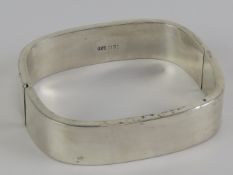 A 925 silver bangle of square form, 5.8 x 5.2cm internal dia, 15mm wide.