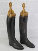 A pair of black leather riding boots, having interior finger pulls, three sectional beechwood trees,