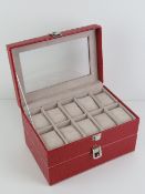A red faux crocodile skin two tier watch box having perspex viewing pane and opening to reveal