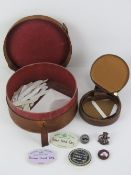 A circular pigskin leather collar box (a/f) containing a quantity of collar stiffeners,