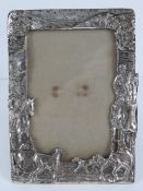 A hunting themed photograph frame having huntsmen on horseback with fox hounds at feet,