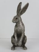 A silver coloured figurine of a Hare sat on its hind legs, 18cm high.