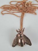 A rose metal pendant in the form of a Napoleonic Bee on a 9ct rose gold adjustable length fine link