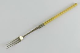 A pickle fork having twist carved ivory handle and white metal fittings, 23cm in length.