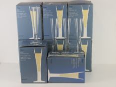 A set of thirty two (eight boxes of four) John Lewis glass champagne flutes, 'as new'.