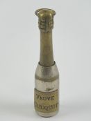 A champagne themed cigar piercer 'Veuve Cliquot', brass and silver plate, standing 7cm high.