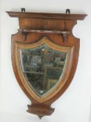 A wall hanging hall mirror having bevel edged shield shaped mirror with shelf over and under 80 x