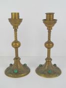 A pair of Gothic Revival brass candlesticks inset with malachite cabachons, each 22cm high.