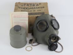 A WWII Dutch gas mask, filter in box wit