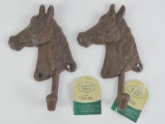 A pair of cast iron coat hooks in the fo