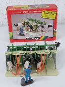 A Britain's milking parlour in original box containing stalls, four dairy cows and attendant.