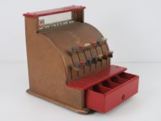 A vintage metal toy till having pop-up prices and cash drawer.