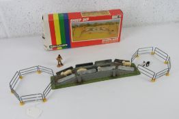 A boxed Britain's farm set sheep dip having four sheep, farmer, sheep dog and railings.