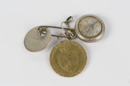George III spade Guinea dated 1793, mounted to onto a safety pin with other charms, overall weight