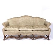 Walnut Carolean style sofa with carved and shaped frame and with loose cushions, 208cm across,