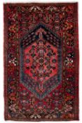 Red ground rug with central medallion and foliate border, 234cm x 170cm approx