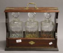 A three bottle tantalus. 41 cm wide.