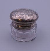 A small unmarked white metal mounted glass viniagrette,