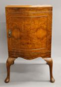 An early 20th century walnut bedside cupboard designed by Maurice Adams and manufactured by Maurice