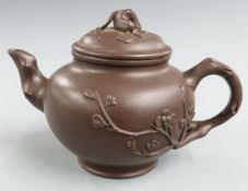 Chinese Yixing teapot with relief floral decoration and four character mark to base, 9.5cm tall