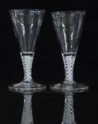 A pair of 18thC ale glasses with white double twist stems and conical shaped bowls raised on conical