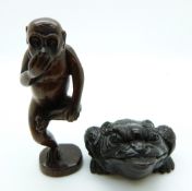 Japanese dark wood netsuke depicting a monkey standing on one leg, together with a dark wood netsuke