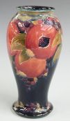 Moorcroft pedestal vase decorated in the Pomegranate pattern including two open pomegranates on a