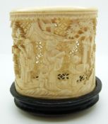 A 19thC carved Chinese ivory pot depicting figures on hardwood stand, 6.5cm
