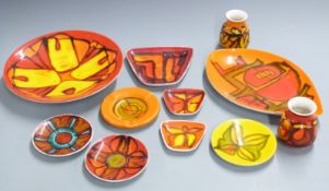Eleven pieces of Poole Delphis pattern dishes and vases including a charger by Carole Cutler,