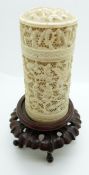 A 19thC carved Chinese ivory pot depicting court scenes, on a hardwood stand, 11cm