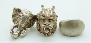 Three Chinese white metal rings, one depicting an elephant and a dragon