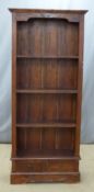 A stained pine bookcase over two drawers, W76 x D28 x H178cm