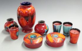 A collection of Poole pottery including a pedestal vase, pair of vases, covered pots and four