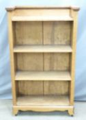 An oak four tier bookshelf with carved frieze, raised on four wheels, W75 D27 H128cm