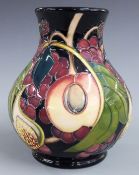 Moorcroft pedestal baluster vase decorated with peaches, figs and grapes, dated 2000, H15cm
