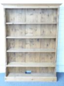 A pine bookcase with turned column decoration and cubbyhole below, W131 x D29 x H179cm