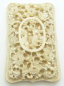 A 19thC Chinese deeply carved ivory shield-shaped card case decorated with chrysanthemums, figural