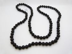 A Chinese necklace made up of caved lacquer prayer beads
