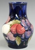 Moorcroft pedestal vase decorated in the Wisteria pattern on a blue ground, impressed and