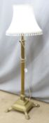 A brass standard lamp with stepped base raised on four lion pad feet, H140cm
