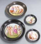 Four Vienna style wall plaques decorated with classical scenes, diameter of largest 22cm