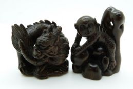 Japanese dark wood netsuke depicting a large monkey climbing rocks and a dark wood netsuke depicting
