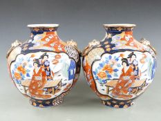 A pair of Japanese Imari bulbous vases with ring handles decorated with figural scenes, 31cm tall