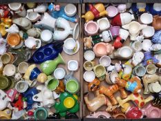 Two trays of novelty ceramic egg cups including aeroplane, figural and animal related items