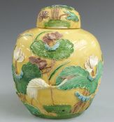 A late 19thC Chinese yellow glaze ginger jar with crane and floral decoration in relief with four