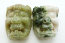 A pair of Chinese Bowenite buckles in the form of masks, 5cm