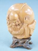 Japanese light wood carving of Daikokuten, the god of wealth, with his sack of money, mounted on a