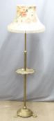 A brass adjustable standard lamp with shelf raised on pad feet, H170cm