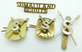 Four Somaliland Scouts metal cap and collar badges, and a shoulder title, one by Gaunt